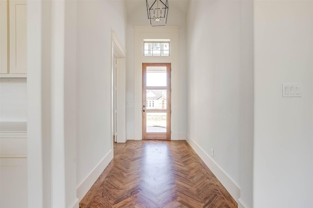 doorway featuring light parquet floors and an inviting chandelier