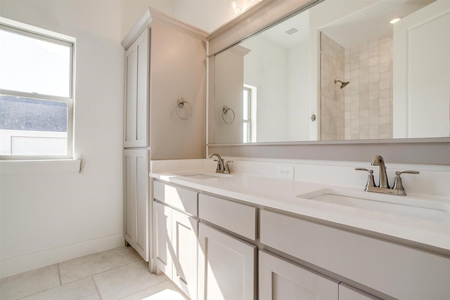 bathroom with double vanity, tile patterned flooring, a sink, and baseboards