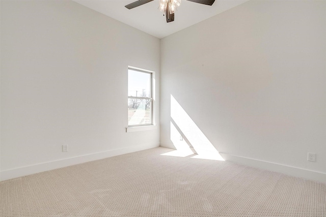 empty room featuring ceiling fan, baseboards, and light colored carpet