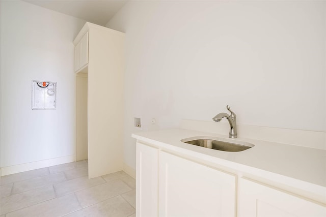 interior space with white cabinets, light tile patterned flooring, and sink