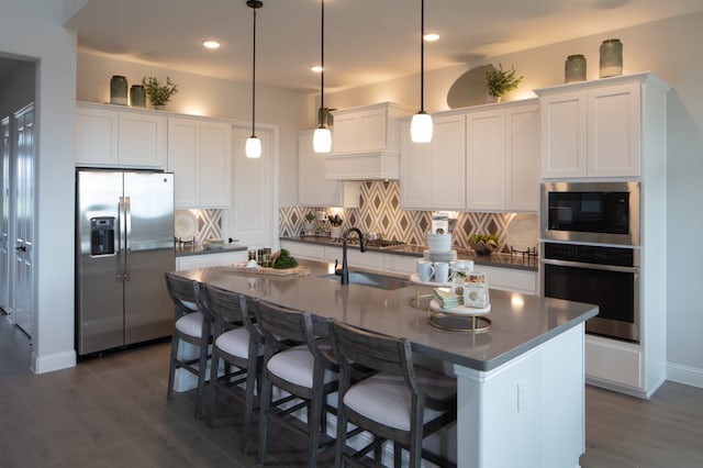 kitchen with white cabinets, decorative light fixtures, and stainless steel appliances