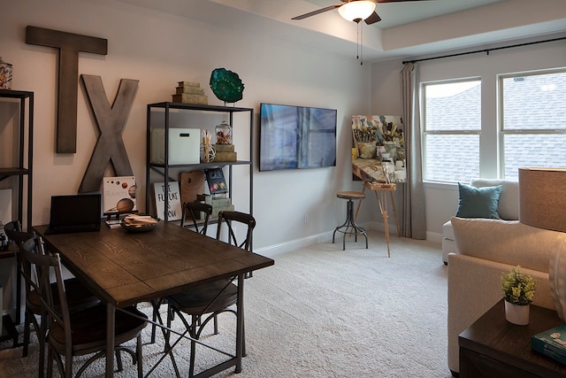 carpeted dining room with ceiling fan