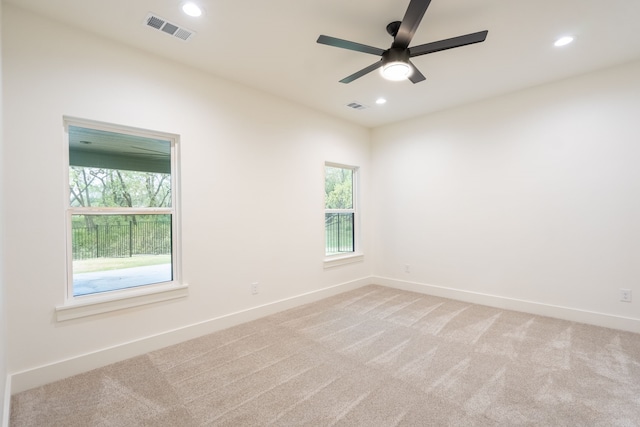 empty room featuring ceiling fan and light colored carpet