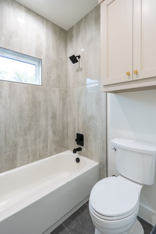 bathroom featuring toilet, tiled shower / bath combo, and tile patterned floors