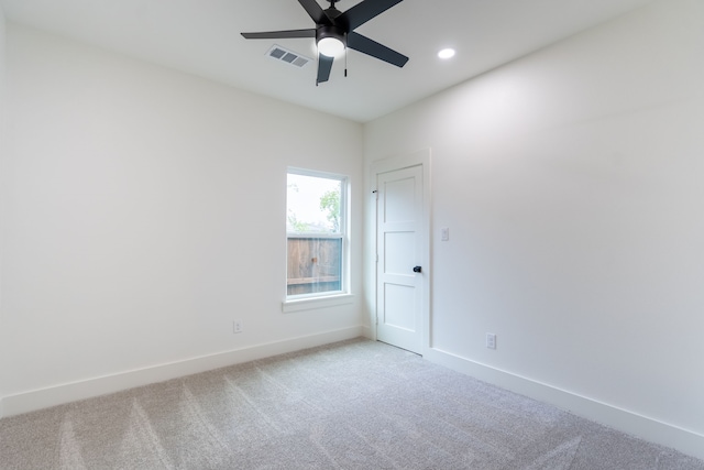 carpeted spare room with ceiling fan