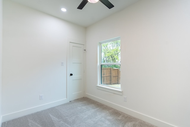 carpeted spare room with ceiling fan