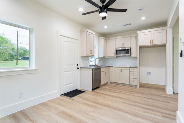 kitchen with white cabinetry, light wood-type flooring, stainless steel appliances, and sink