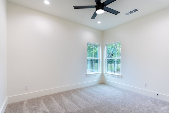 carpeted spare room with ceiling fan