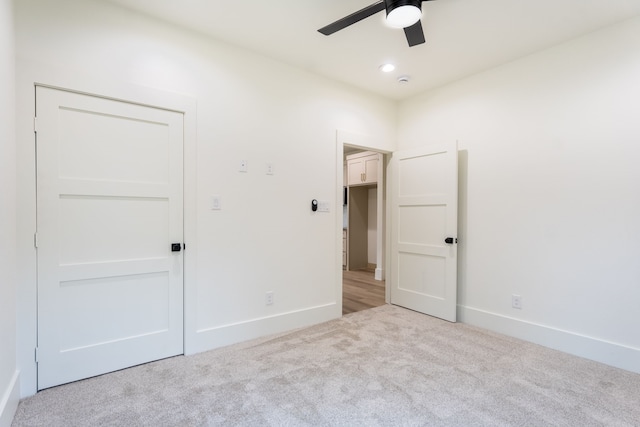 unfurnished bedroom featuring light carpet and ceiling fan