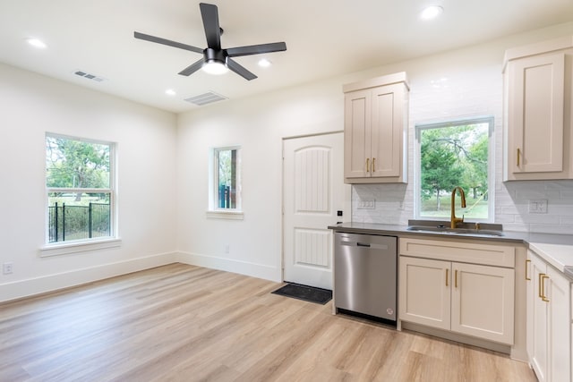 kitchen with stainless steel dishwasher, plenty of natural light, sink, and light wood-type flooring