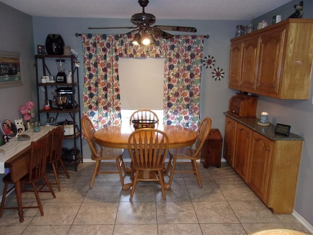 dining space featuring light tile patterned flooring, ceiling fan, and a textured ceiling