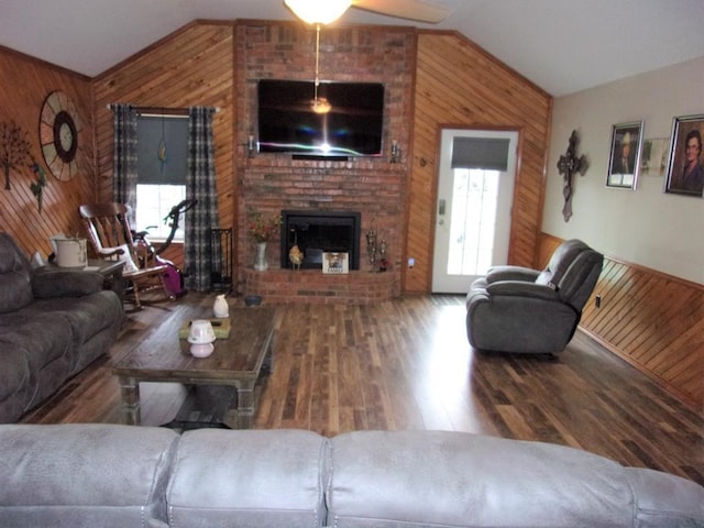 living room with hardwood / wood-style flooring, lofted ceiling, and wooden walls