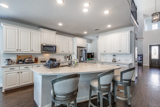 kitchen with white cabinetry, a kitchen island with sink, and stainless steel appliances