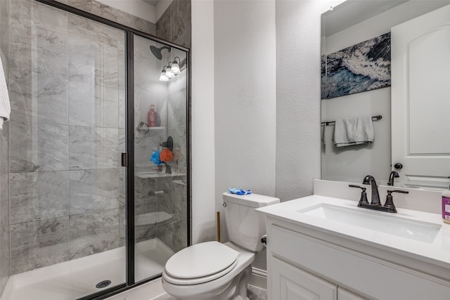 bathroom with a shower with door, vanity, and toilet