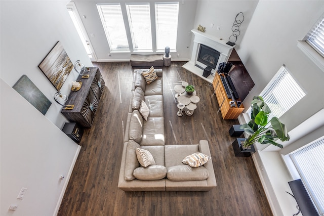 living room featuring dark hardwood / wood-style flooring and a towering ceiling