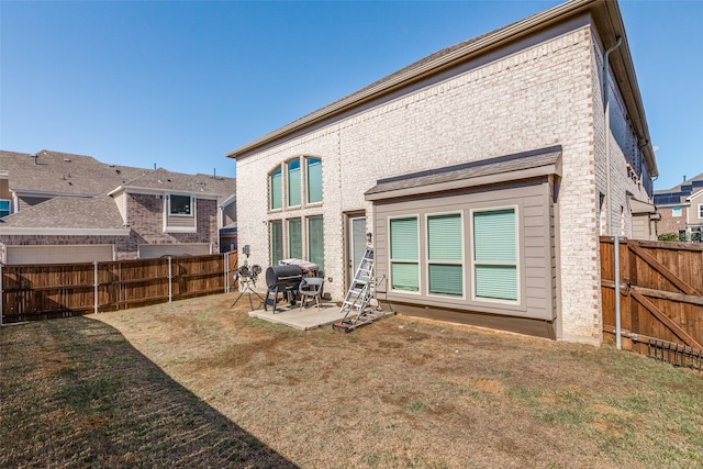 back of house with a lawn and a patio