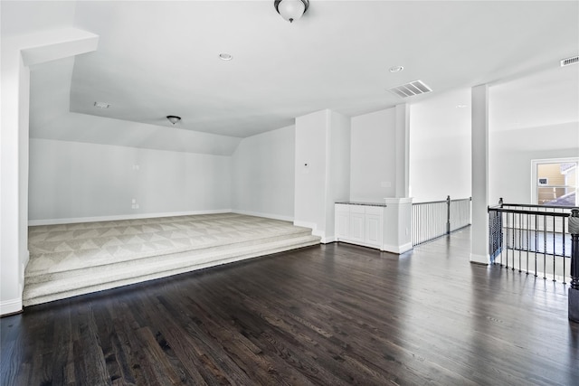 bonus room with dark hardwood / wood-style floors and vaulted ceiling