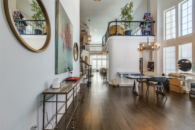 interior space with dark hardwood / wood-style flooring, a towering ceiling, and plenty of natural light