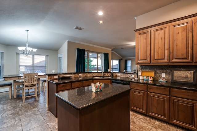 kitchen featuring a healthy amount of sunlight, a kitchen island, vaulted ceiling, and sink