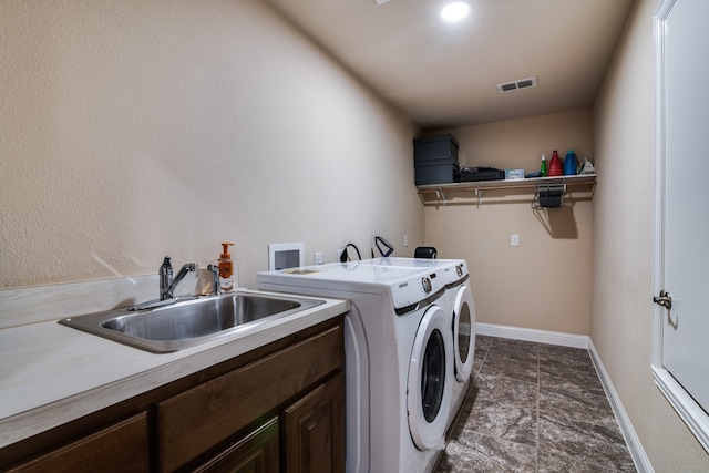 washroom with washer and clothes dryer, cabinets, and sink