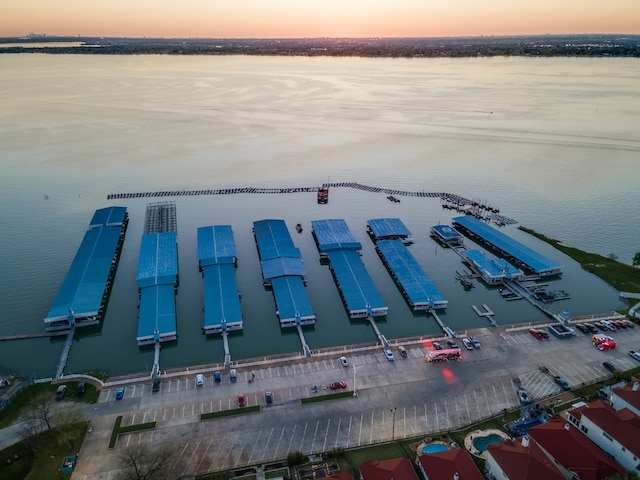 aerial view at dusk featuring a water view