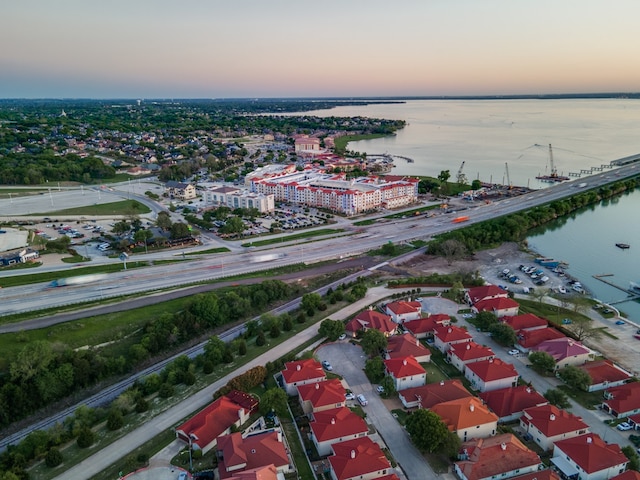 aerial view at dusk featuring a water view