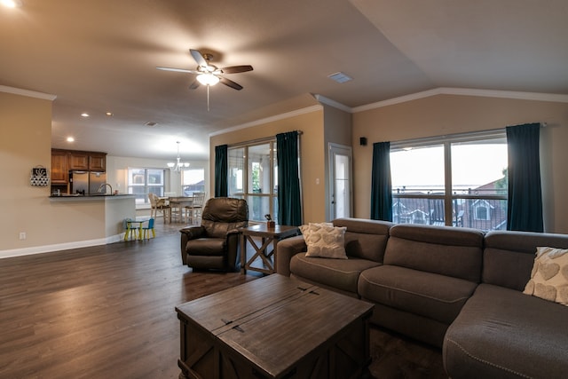 living room with dark wood-type flooring, a wealth of natural light, ornamental molding, and ceiling fan with notable chandelier