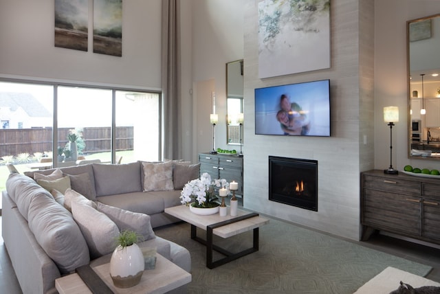 living room with a large fireplace and a towering ceiling