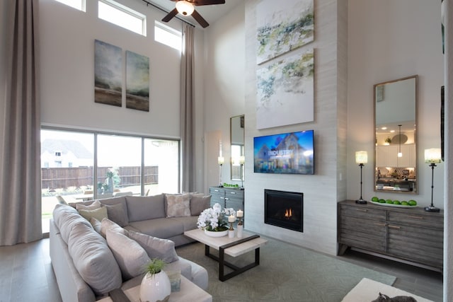 living room featuring plenty of natural light, a fireplace, hardwood / wood-style floors, and a towering ceiling