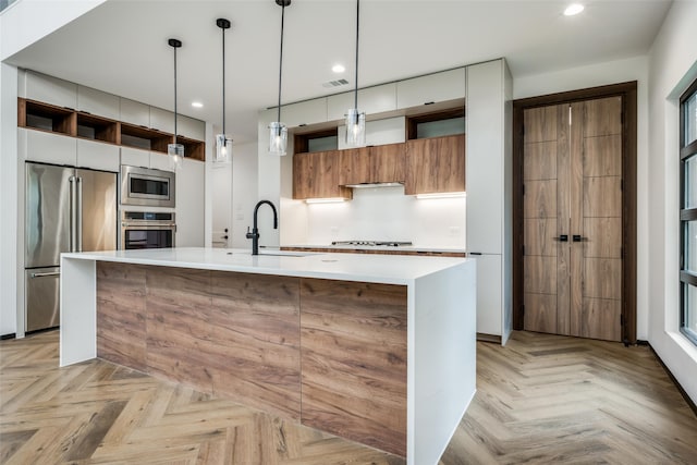 kitchen featuring hanging light fixtures, sink, light parquet floors, and stainless steel appliances