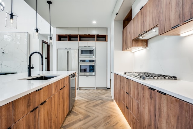 kitchen featuring appliances with stainless steel finishes, backsplash, sink, decorative light fixtures, and light parquet flooring