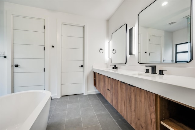 bathroom with vanity, tile patterned floors, and a bathing tub