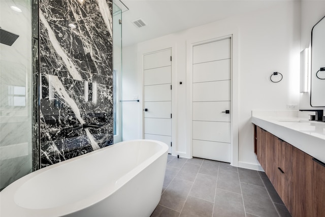 bathroom featuring tile patterned flooring, shower with separate bathtub, and vanity