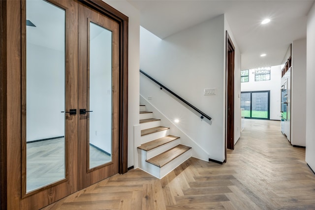 stairs with parquet flooring and french doors