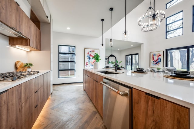3050 Tall Oaks Ct, Corinth, TX 76210 - kitchen featuring modern cabinets, appliances with stainless steel finishes, a sink, brown cabinetry, and pendant lighting