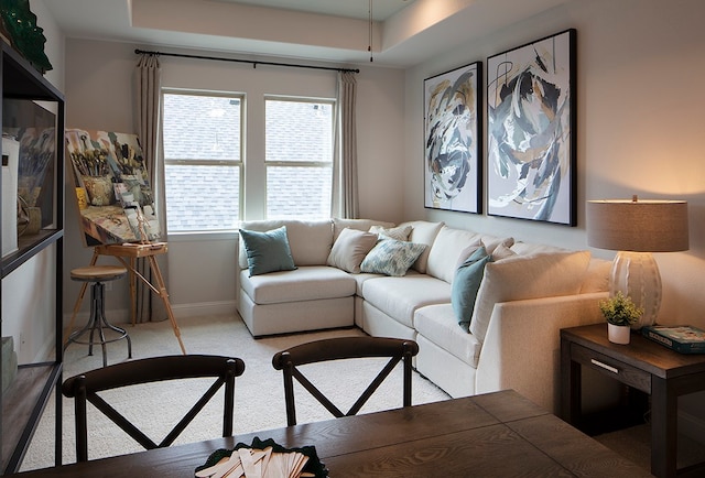 living room with light colored carpet and a tray ceiling