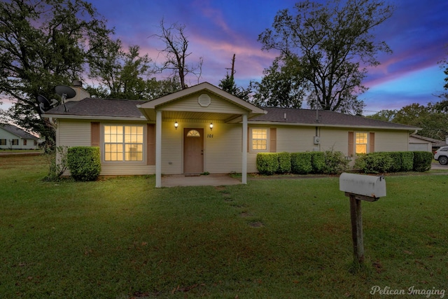 single story home with a lawn