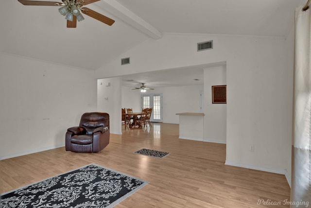 living area featuring ceiling fan, light wood-type flooring, and vaulted ceiling with beams