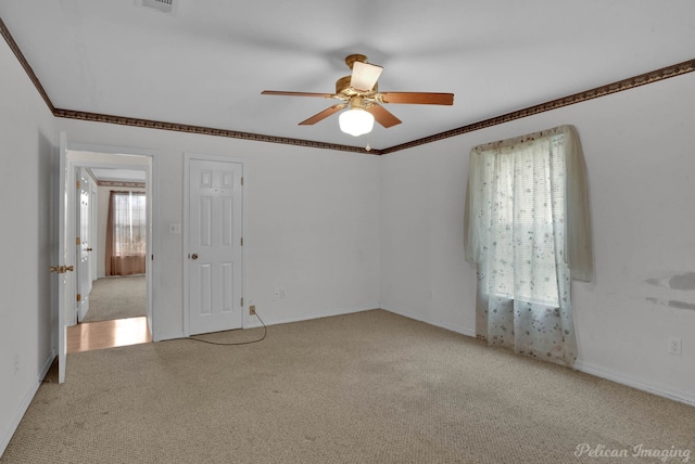 carpeted empty room featuring ornamental molding and ceiling fan