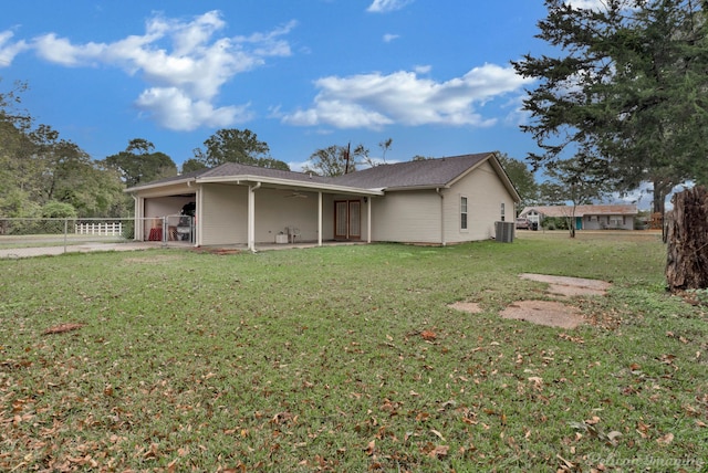 back of property featuring central AC unit, a patio area, and a lawn