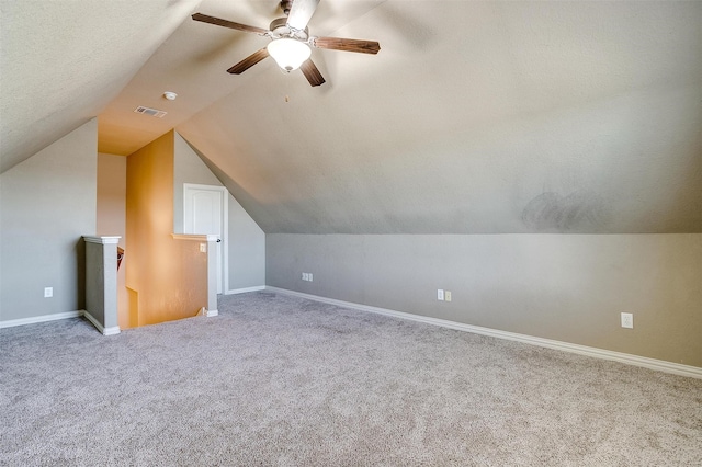 bonus room featuring a textured ceiling, light carpet, ceiling fan, and lofted ceiling