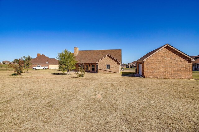 140 Champion Ct, Weatherford, TX 76087 - rear view of house with brick siding and a chimney