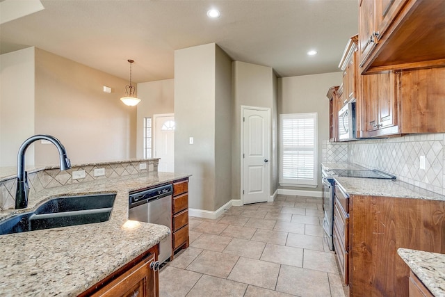 140 Champion Ct, Weatherford, TX 76087 - kitchen featuring stainless steel appliances, a sink, brown cabinetry, backsplash, and baseboards
