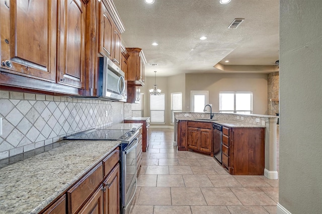 140 Champion Ct, Weatherford, TX 76087 - kitchen featuring stainless steel appliances, decorative backsplash, a textured ceiling, baseboards, and a sink