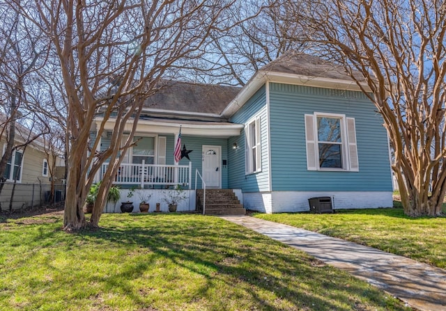 bungalow-style home with central air condition unit, a front yard, and covered porch