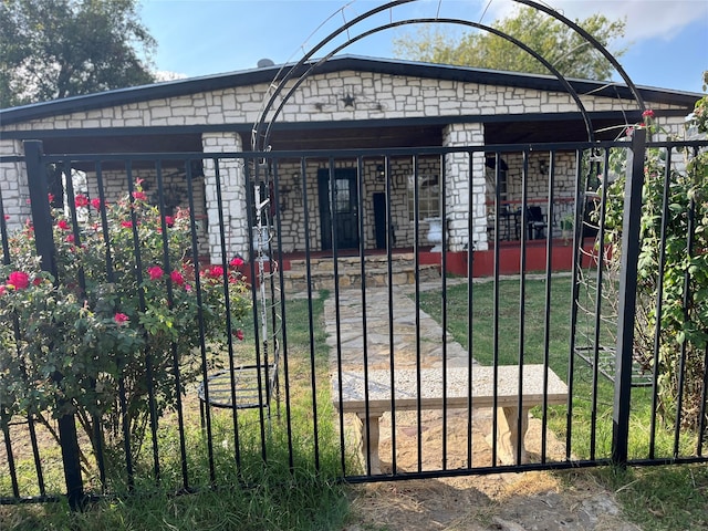 view of gate with a lawn