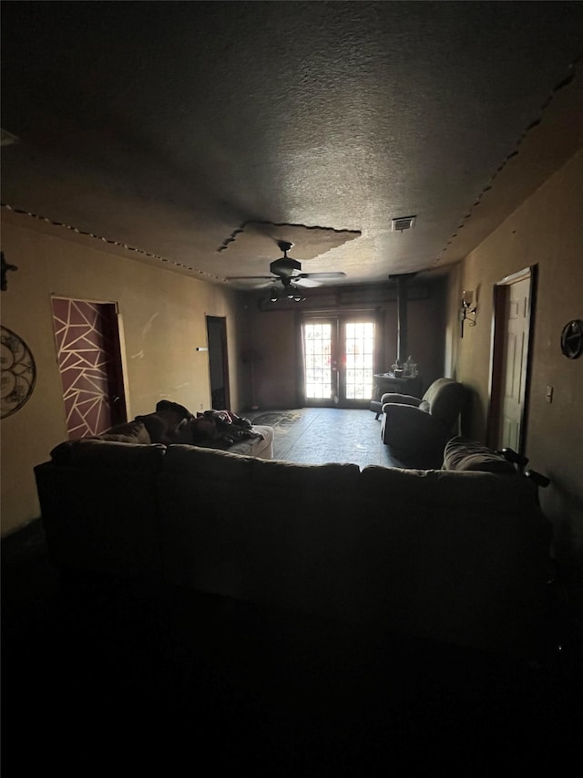 living room featuring french doors, a textured ceiling, and ceiling fan