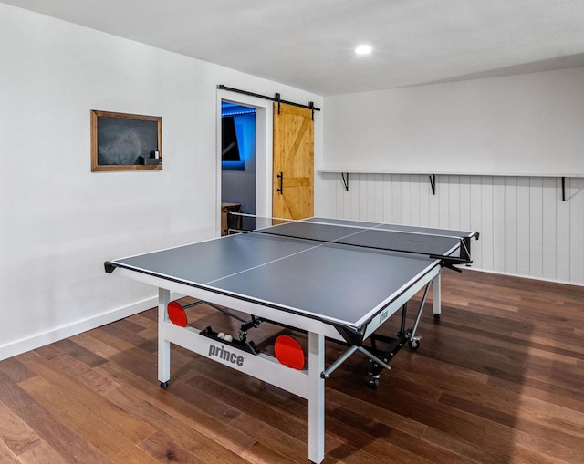 recreation room with dark wood-type flooring and a barn door