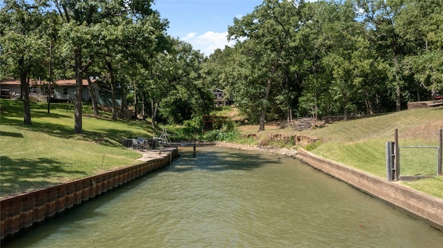 view of community featuring a water view and a lawn