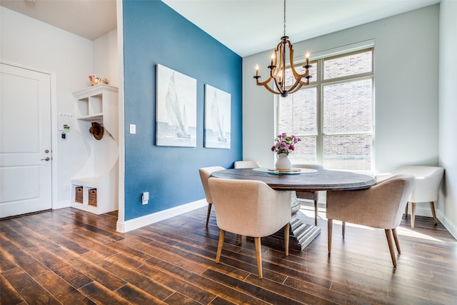 dining area featuring dark wood-type flooring and an inviting chandelier